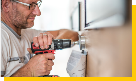 shopfitter drilling into wall